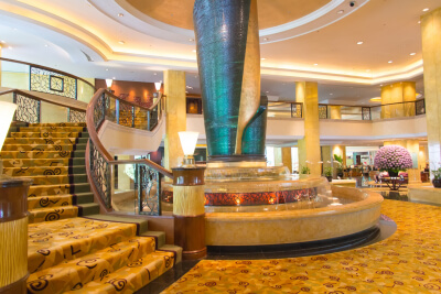 luxury hotel lobby with staircases and fountain